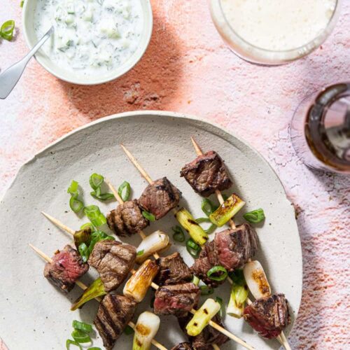 Barbecue spiesjes van gemarineerde biefstuk en lente-ui, met yoghurtdip